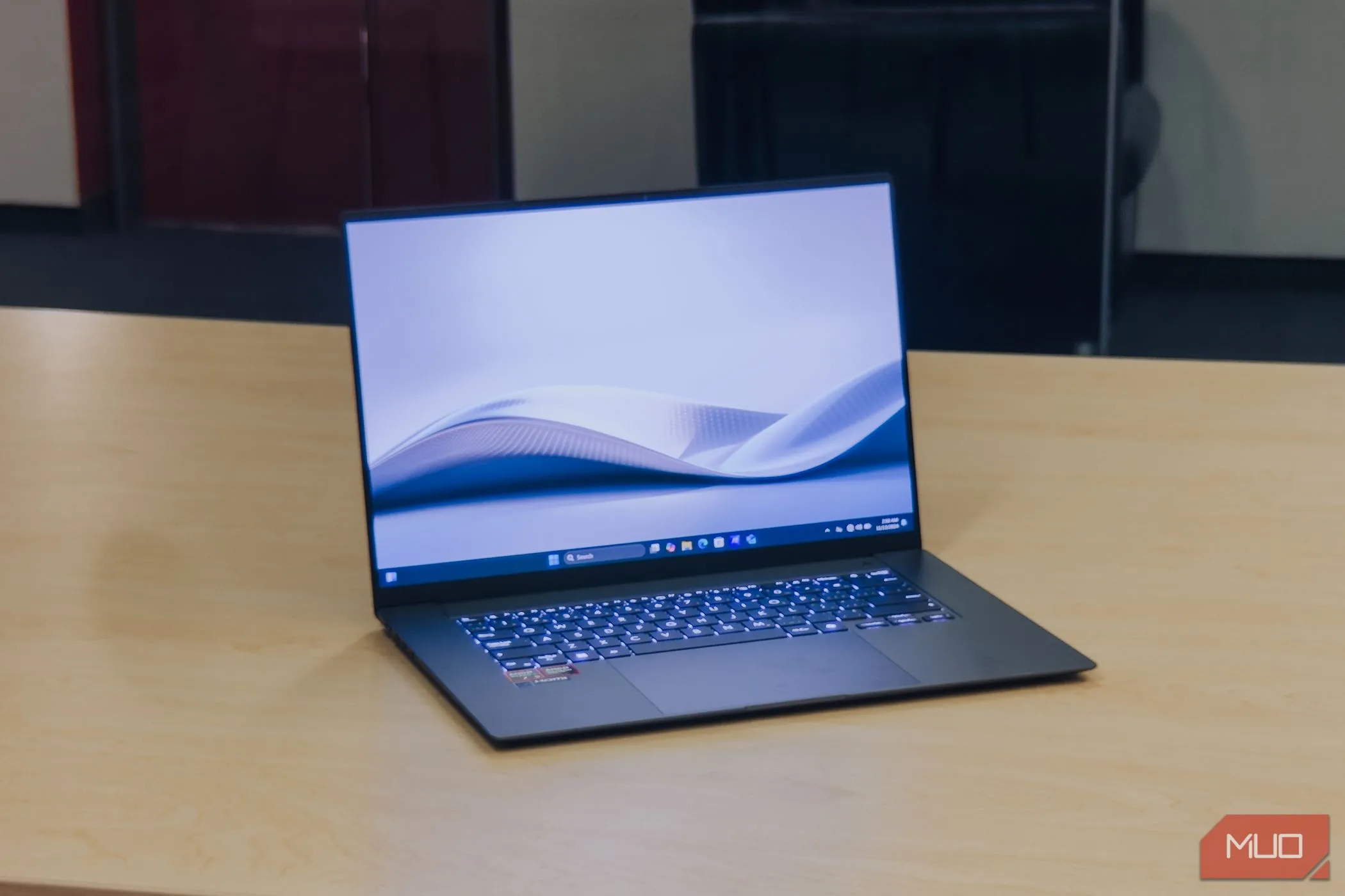 ASUS Zenbook S 16 với màn hình hiển thị nội dung trên bàn gỗ, biểu thị hiệu năng mạnh mẽ