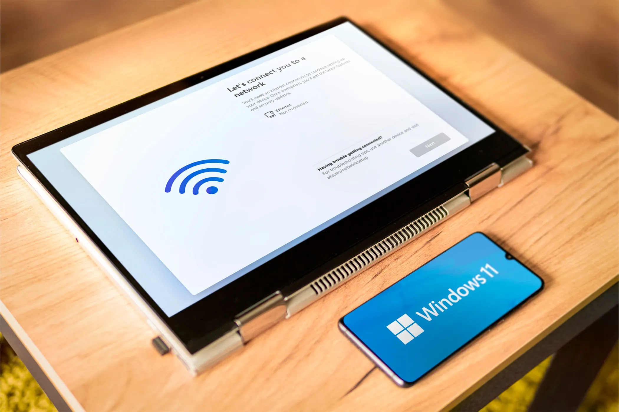 Biểu tượng Windows 11 trên laptop và điện thoại, minh họa khả năng điều khiển PC từ xa bằng Android.