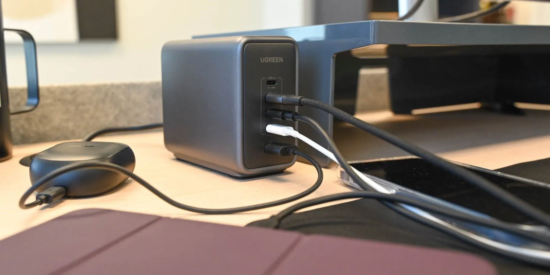 Bộ sạc UGreen Nexode 300W với bốn thiết bị USB-C đang được cắm sạc trên bàn.