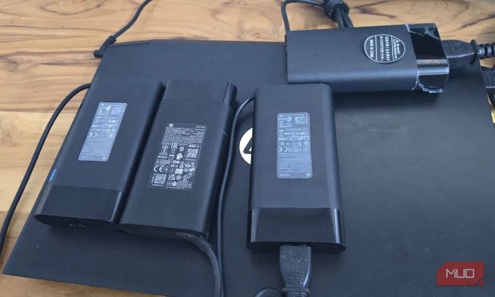 Bốn cục sạc HP 150W đã hỏng đặt cạnh laptop HP, minh họa chi phí thay thế do cổng sạc duy nhất gặp vấn đề
