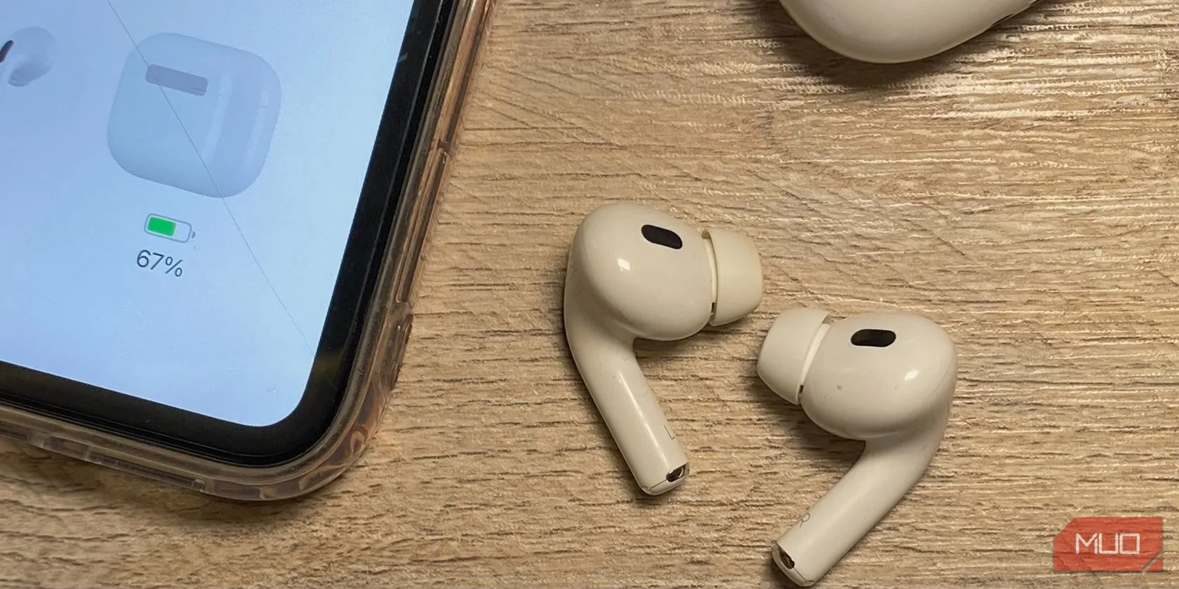Các mẫu tai nghe AirPods đặt trên bàn gỗ cạnh iPhone