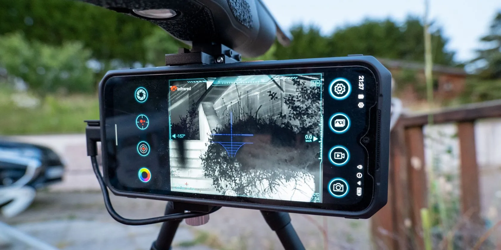 Camera nhiệt hồng ngoại Xinfrared X2 cắm vào smartphone, đặt trên chân máy ảnh.