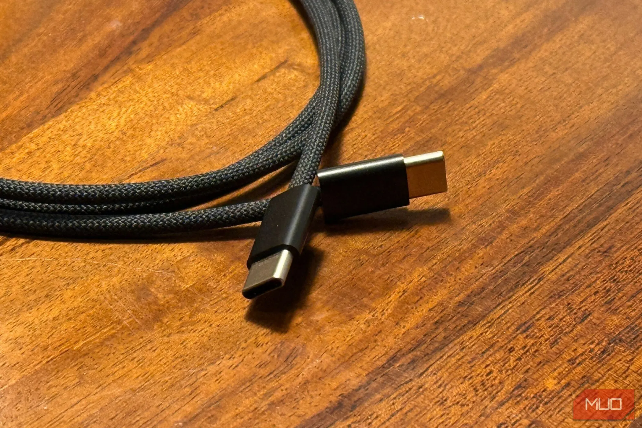 Cáp sạc USB-C to USB-C đặt trên mặt bàn gỗ, loại cáp hiện đại dùng cho iPhone 15 series