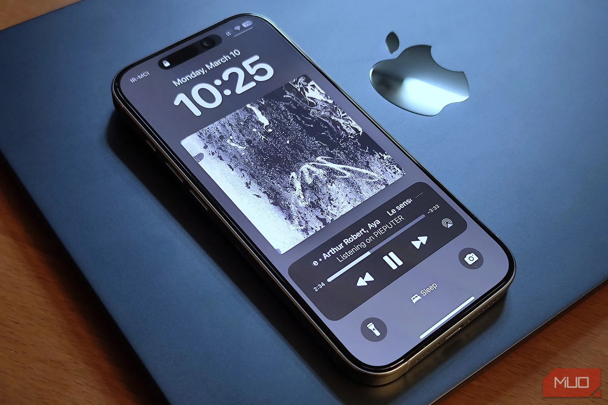 Chiếc iPhone 16 Pro đặt cạnh MacBook Air, biểu tượng cho sự đồng bộ của hệ điều hành iOS.