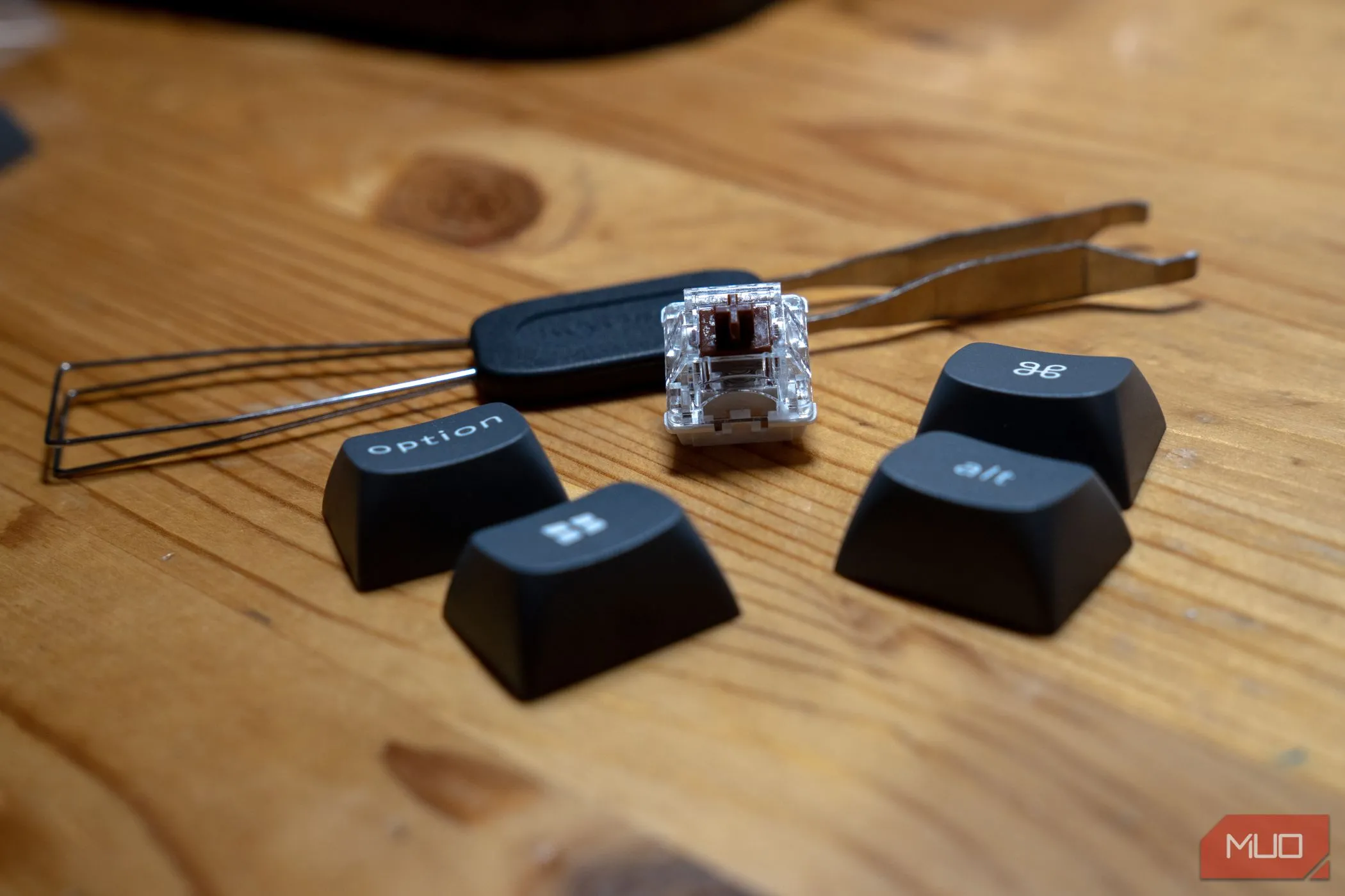 Công cụ gỡ keycap và switch đi kèm Keychron K8 Max, cùng với một số keycap và switch rời, minh họa khả năng hot-swappable.