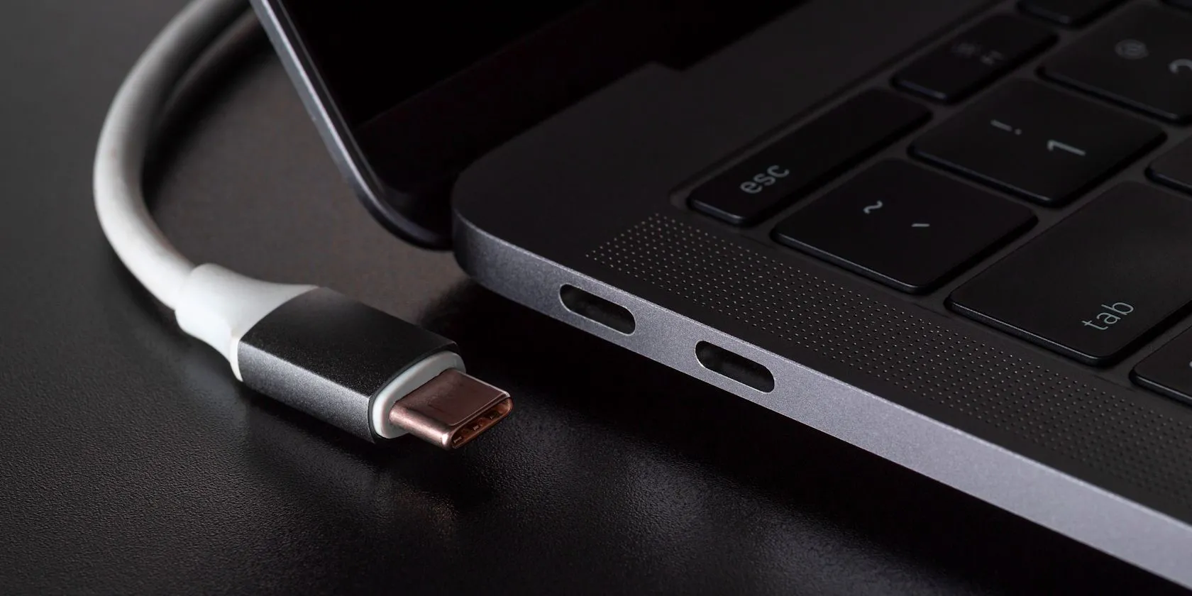 Cổng kết nối USB-C trên laptop với cáp sạc được cắm vào, thể hiện việc sạc nhanh trong chế độ ngủ