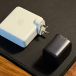 Củ sạc điện thoại nhỏ gọn đặt cạnh adapter MacBook lớn, minh họa sự khác biệt về kích thước và công suất