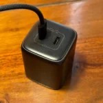 Củ sạc điện thoại với cáp sạc USB-C đang cắm, đặt trên bàn làm việc, minh họa cho công suất sạc nhanh