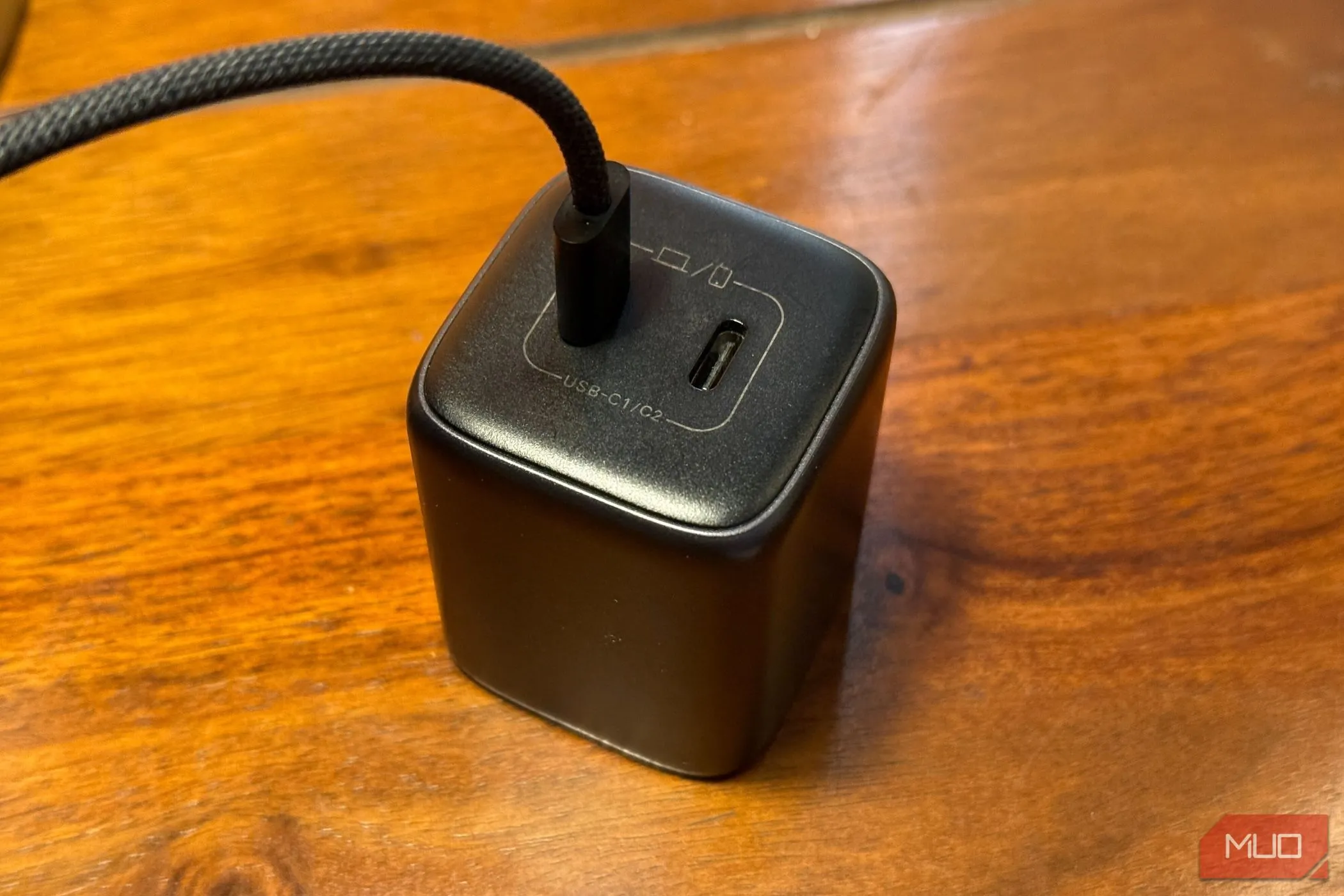 Củ sạc điện thoại với cáp sạc USB-C đang cắm, đặt trên bàn làm việc, minh họa cho công suất sạc nhanh