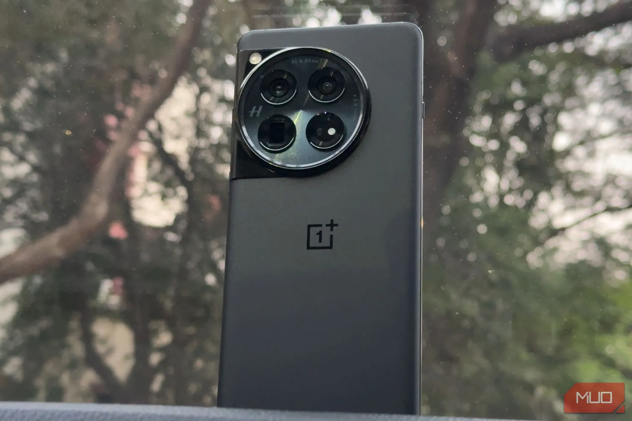 Điện thoại OnePlus 12 màu đen trên bảng điều khiển ô tô thể hiện sự sang trọng và tiện dụng