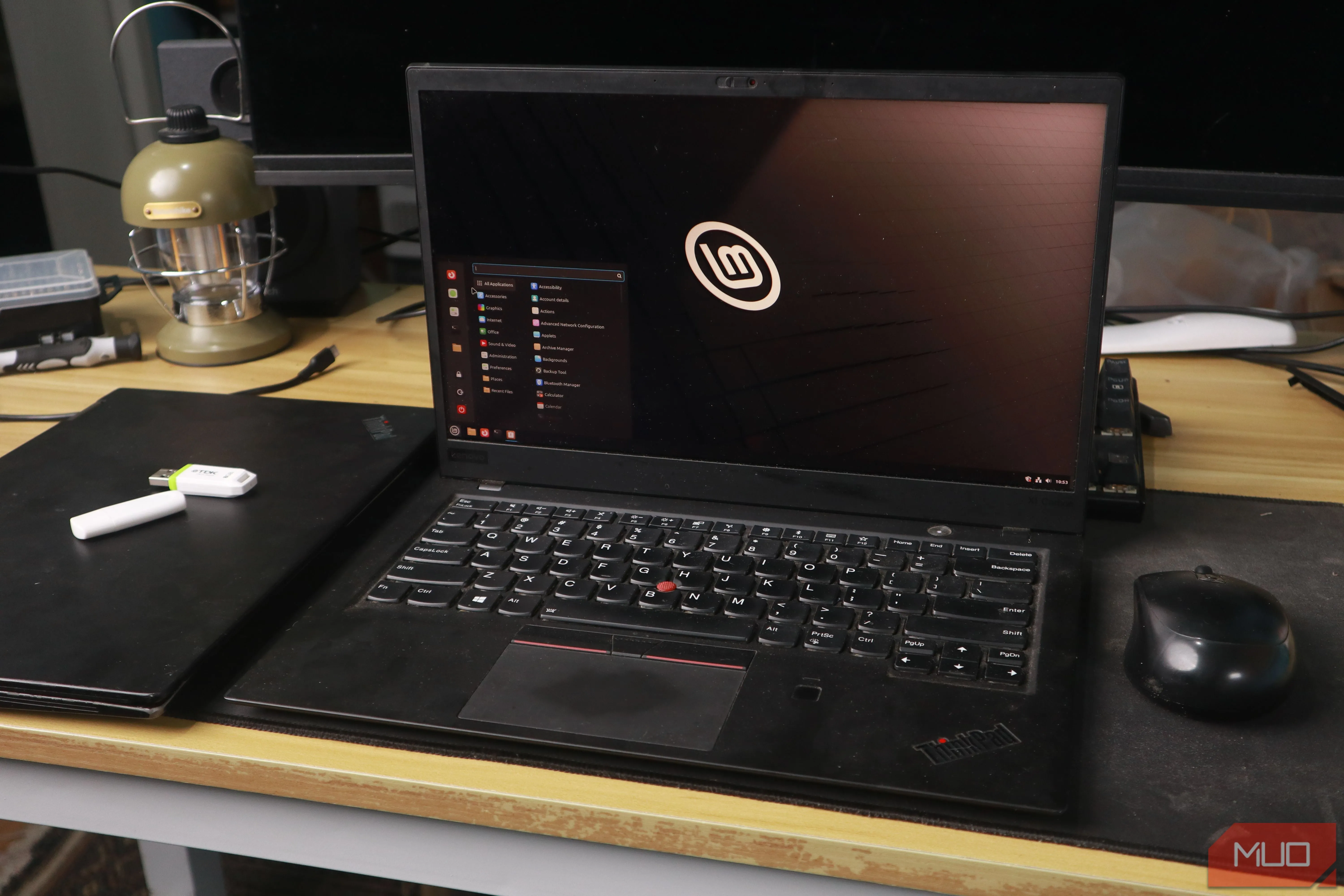Giao diện Linux Mint trên laptop ThinkPad cùng chuột và USB cài đặt