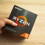 Hình ảnh một người đàn ông cầm hộp bộ vi xử lý AMD Ryzen 5, nhấn mạnh tầm quan trọng của CPU trong laptop giá rẻ