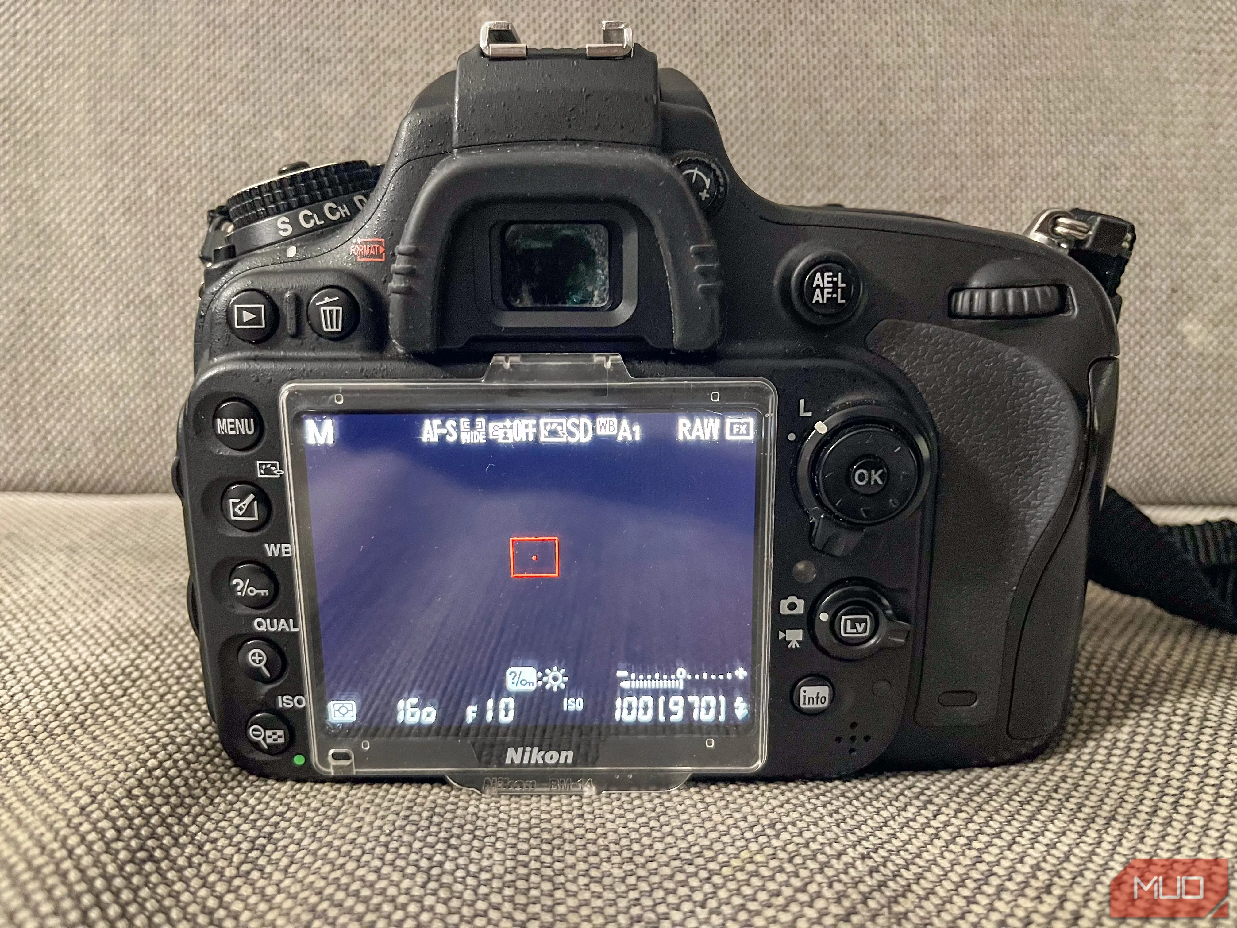 Hình ảnh người chụp đang nhìn qua kính ngắm quang học (OVF) của máy ảnh DSLR, mô tả trải nghiệm ngắm trực tiếp và chân thực.
