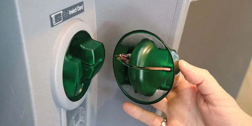Hình ảnh so sánh thiết bị card skimmer gắn chồng lên đầu đọc thẻ ATM và đầu đọc thẻ thật