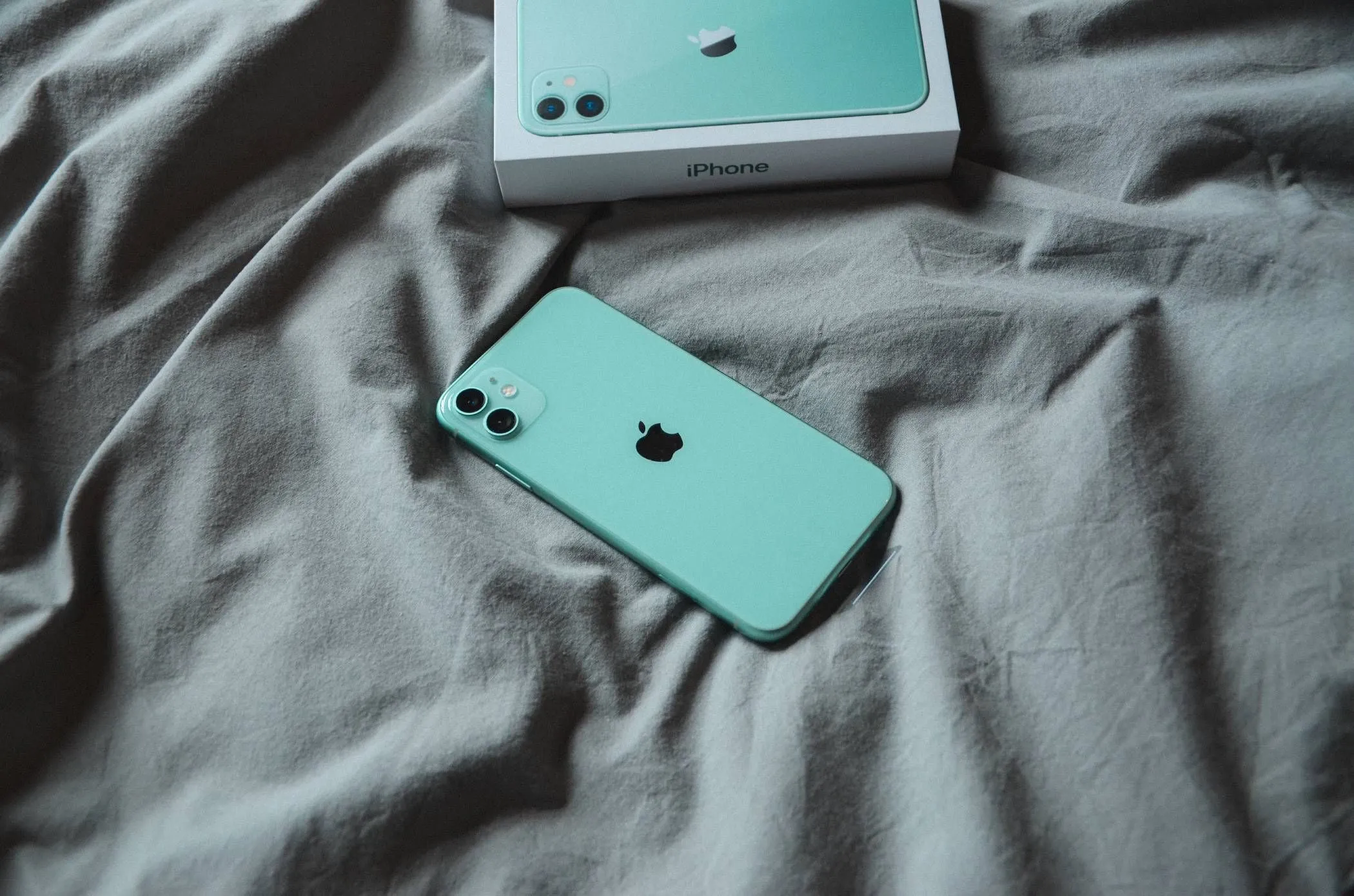 iPhone 11 nằm trên chăn mềm