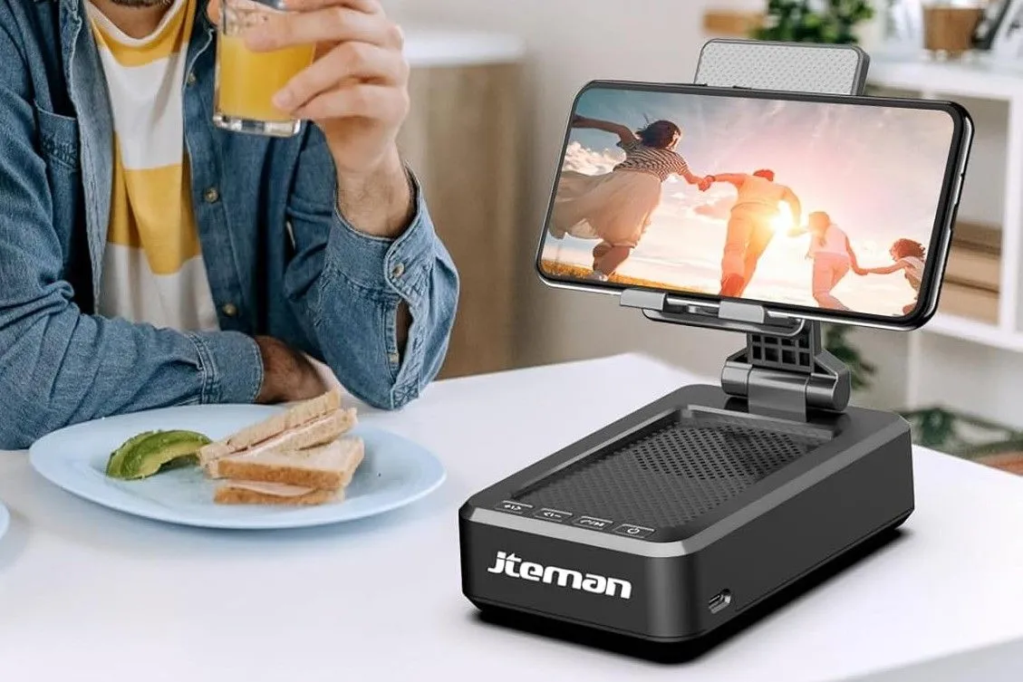 iPhone được đặt trên dock loa trên bàn trắng, minh họa cách biến loa thường thành loa thông minh bằng iPhone cũ