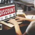 Laptop hiển thị nhãn giảm giá và quảng cáo khuyến mãi trên màn hình
