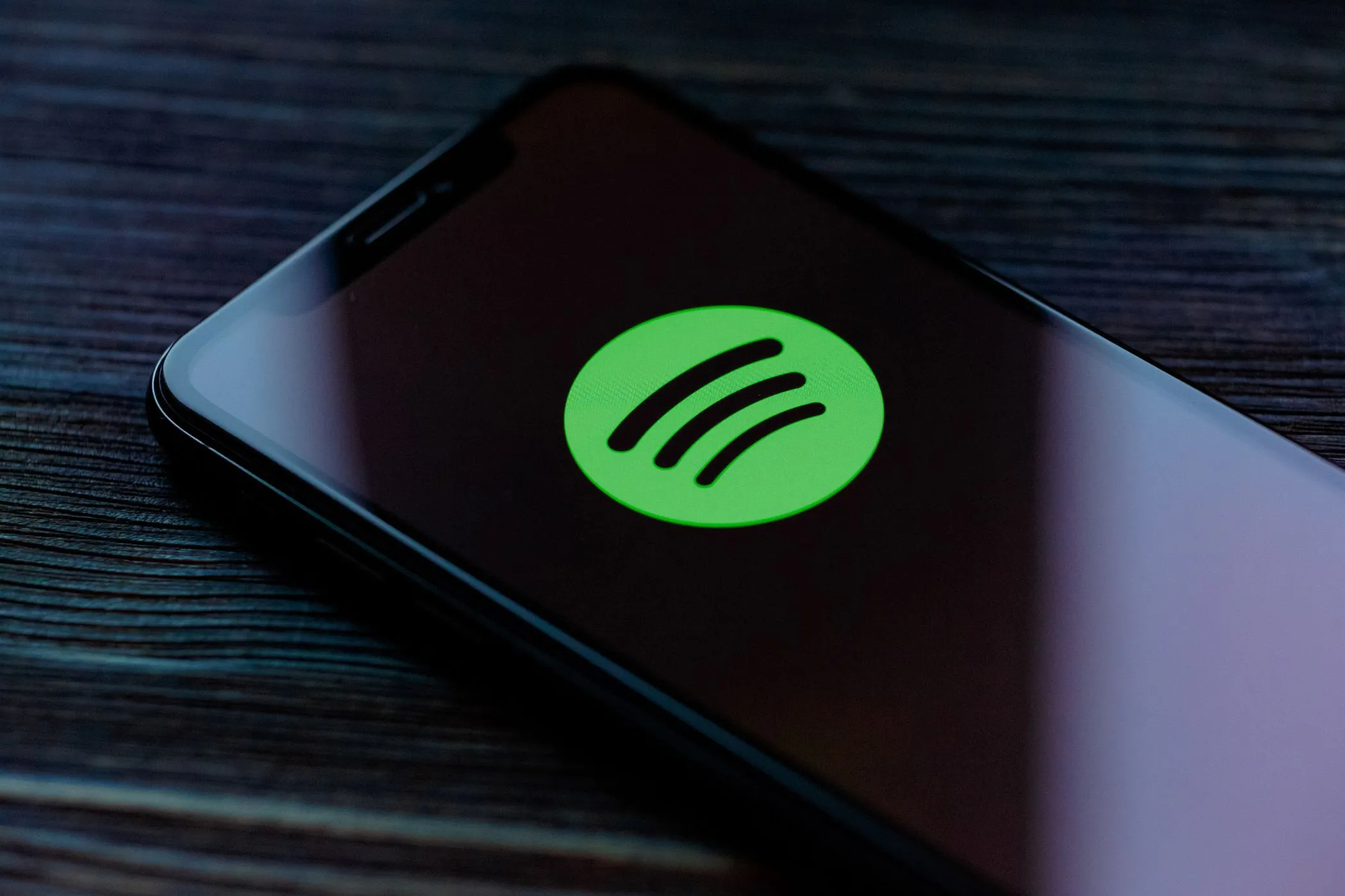 Logo Spotify trên điện thoại thông minh, minh họa cho việc ứng dụng nghe nhạc này thu thập chi tiết thói quen nghe và dữ liệu cảm biến để phục vụ quảng cáo.
