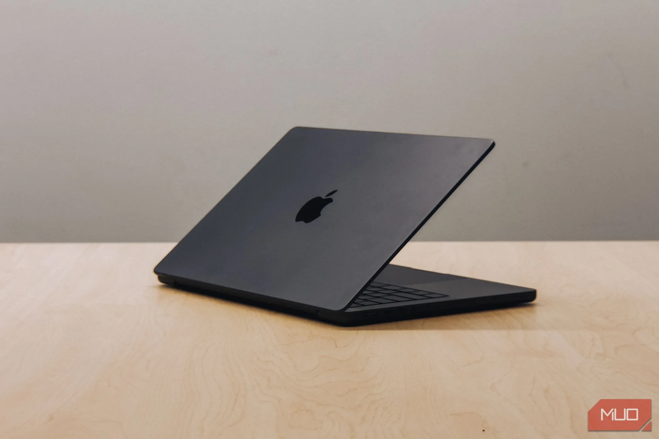 M4 MacBook Pro đặt nghiêng trên bàn gỗ, thể hiện xu hướng chuyển đổi sang chip Apple Silicon của Apple