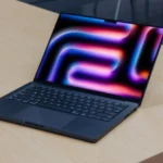 M4 MacBook Pro trên bàn gỗ, màn hình ngửa, tượng trưng cho thế hệ Mac mới dùng chip Apple Silicon