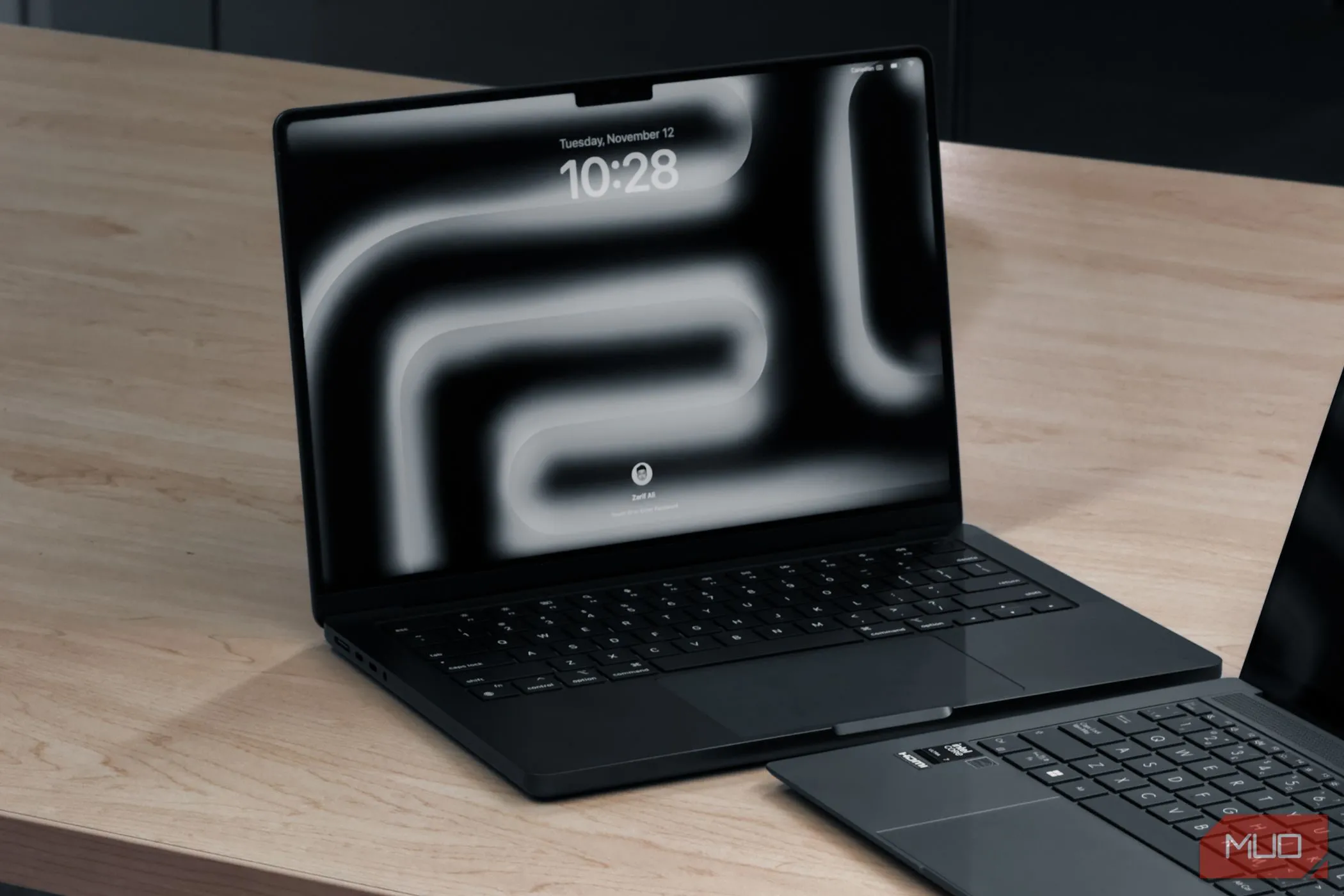 MacBook Pro M4 và một laptop khác đặt trên bàn gỗ