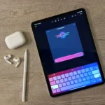 Màn hình Genmoji trên iPad, đi kèm tai nghe AirPods và bút Apple Pencil, minh họa các phụ kiện Apple phổ biến