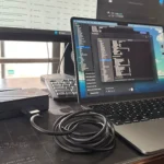 Màn hình ngoài và MacBook kết nối qua hub, minh họa việc sử dụng nhiều màn hình gây hao pin laptop.
