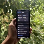 Một bàn tay đang cầm iPhone với menu iCloud đang mở