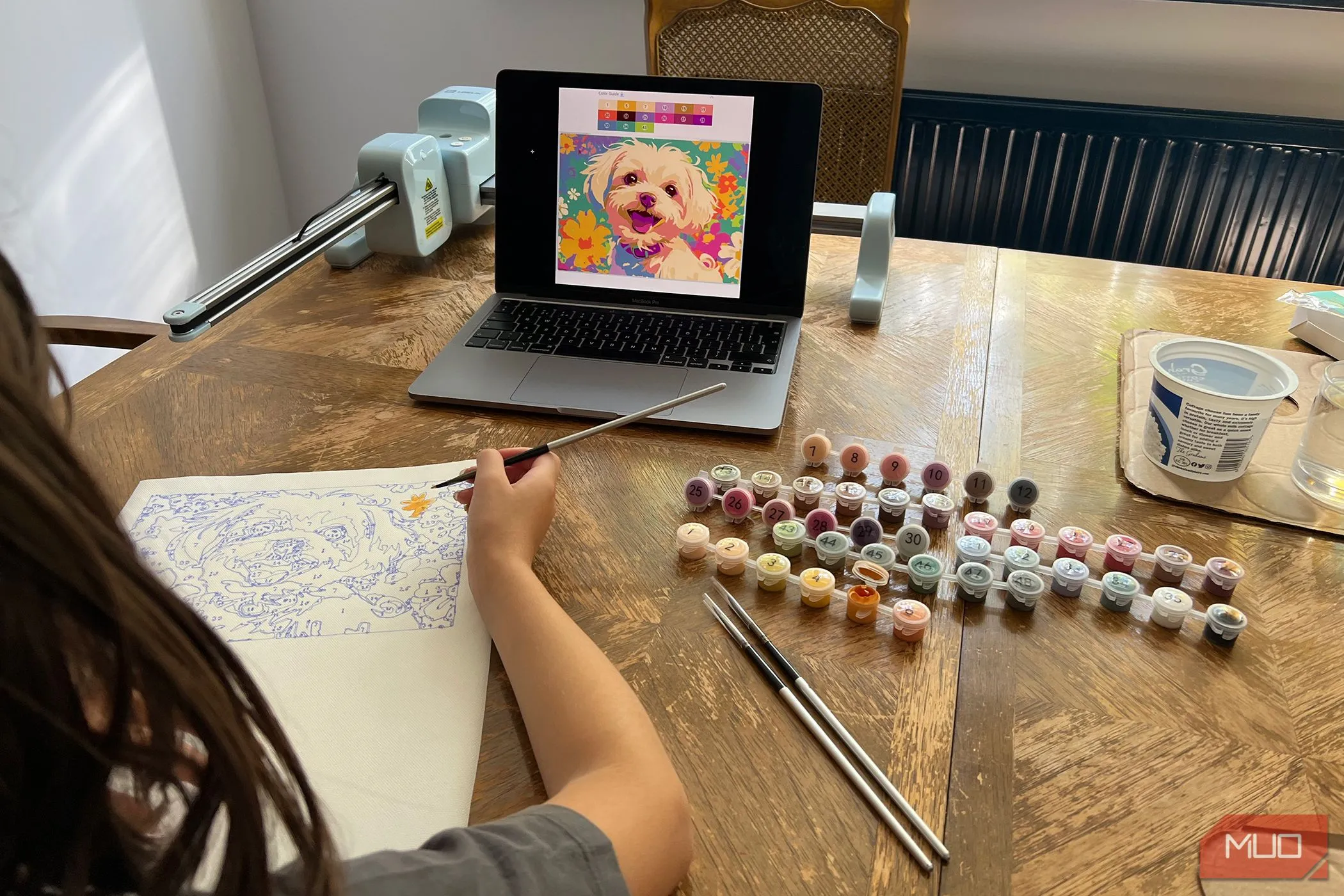 Một bé gái đang tô màu tranh chú chó được vẽ tự động bằng máy LOKLiK iPaint