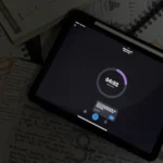 Một chiếc iPad hiển thị ứng dụng đếm giờ học tập, xung quanh có giấy ghi chú và bút.