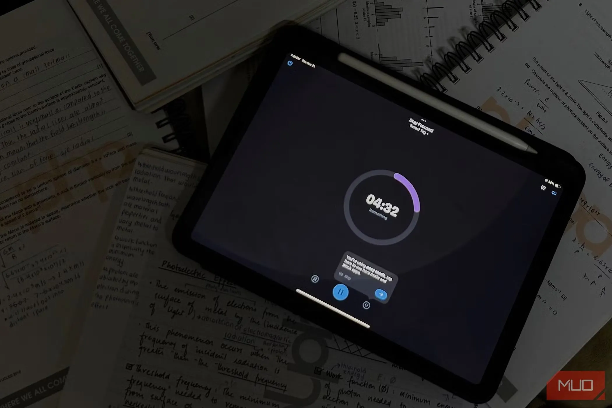 Một chiếc iPad hiển thị ứng dụng đếm giờ học tập, xung quanh có giấy ghi chú và bút.