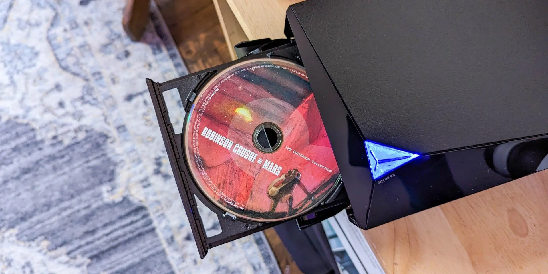 Một đầu phát DVD của Asus với khay đĩa đang mở ra, sẵn sàng cho một đĩa phim.
