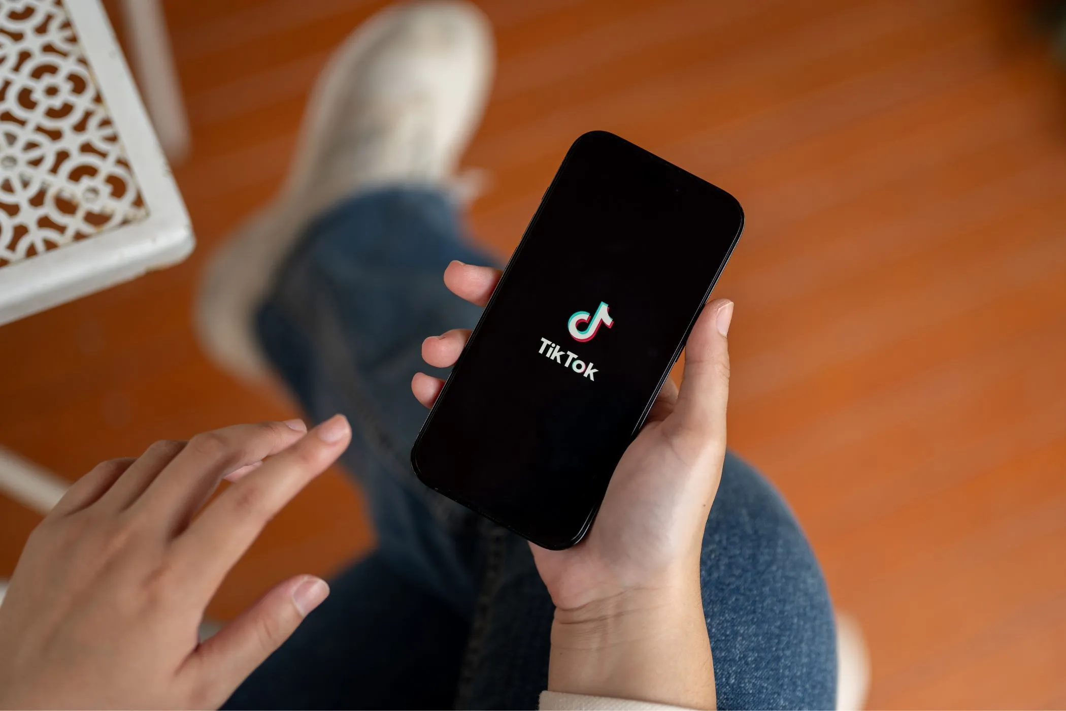 Một người đang cầm điện thoại thông minh hiển thị ứng dụng TikTok, minh họa cho việc TikTok thu thập và chia sẻ thông tin cá nhân.