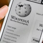 Một người dùng đang mở ứng dụng Wikipedia trên điện thoại để tra cứu thông tin, minh họa cách AI sẽ cải thiện khả năng khám phá nội dung trên nền tảng này.