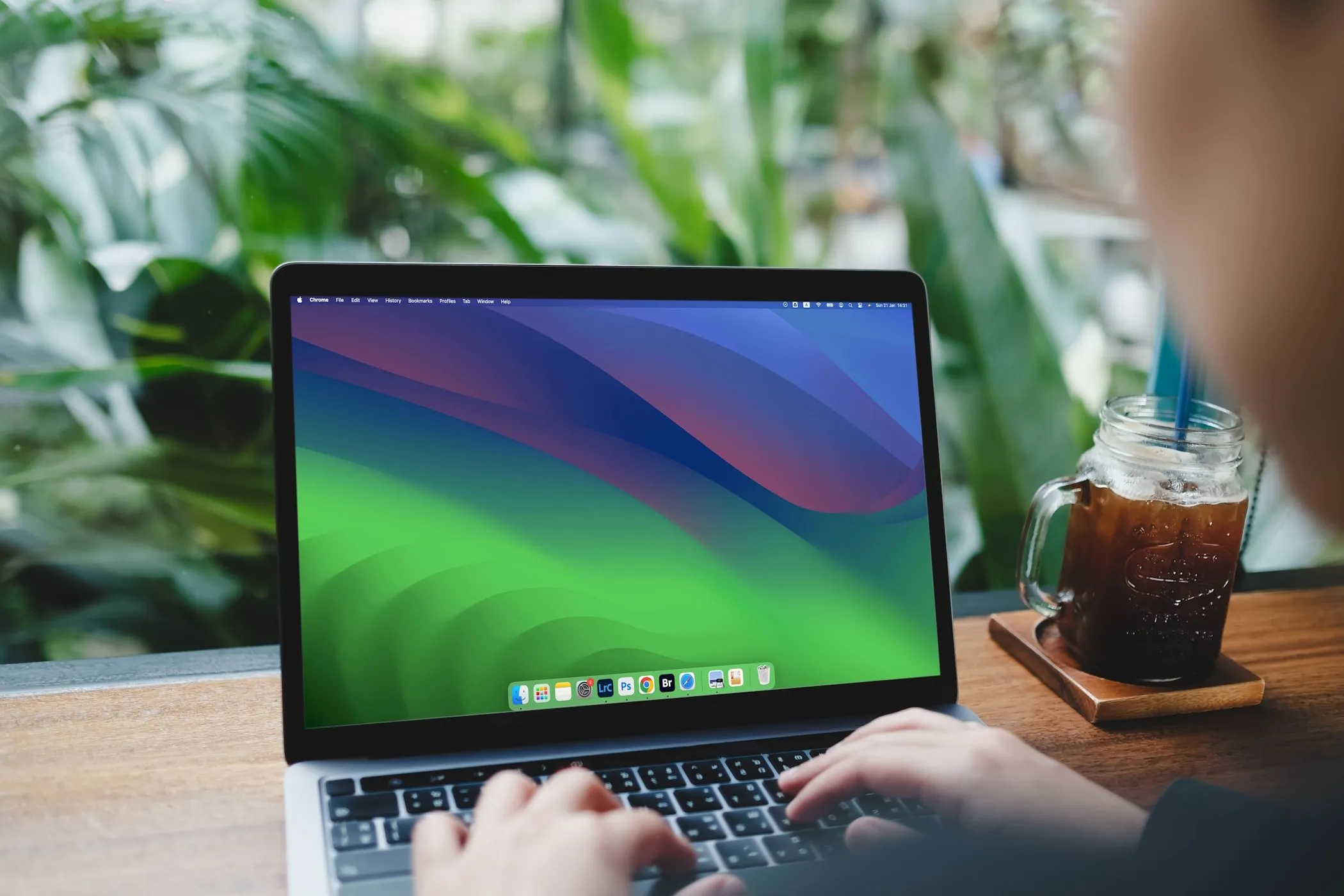 Một người phụ nữ đang gõ bàn phím trên máy tính MacBook Air chạy macOS Sonoma