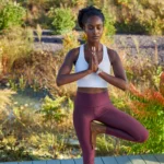 Một phụ nữ đang tập yoga với đồng hồ Garmin Quatix 6X Solar trên cổ tay, thể hiện khả năng theo dõi sức khỏe và thể chất.