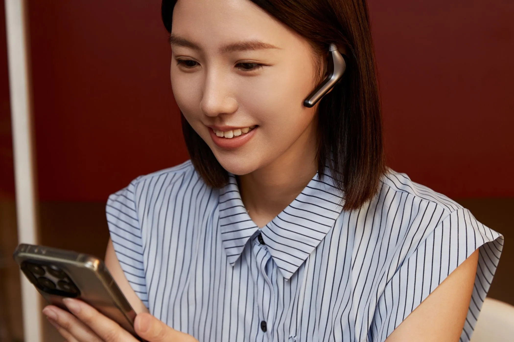 Một phụ nữ trẻ gọi video, sử dụng tai nghe Timekettle W4 Pro tích hợp AI liên tục phát triển