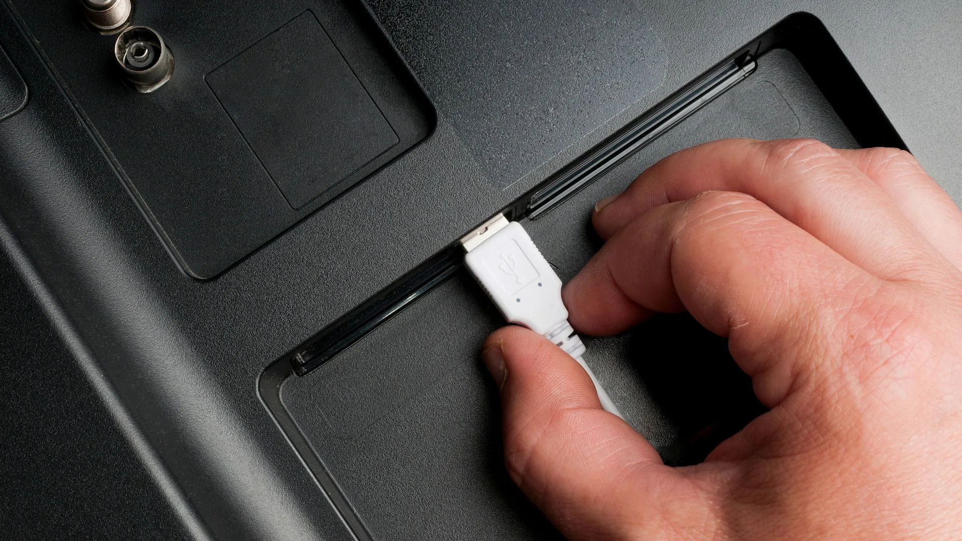 Người đàn ông cắm cáp USB vào thiết bị điện tử, nhấn mạnh sự đa dạng của cổng USB và đầu ra sạc.