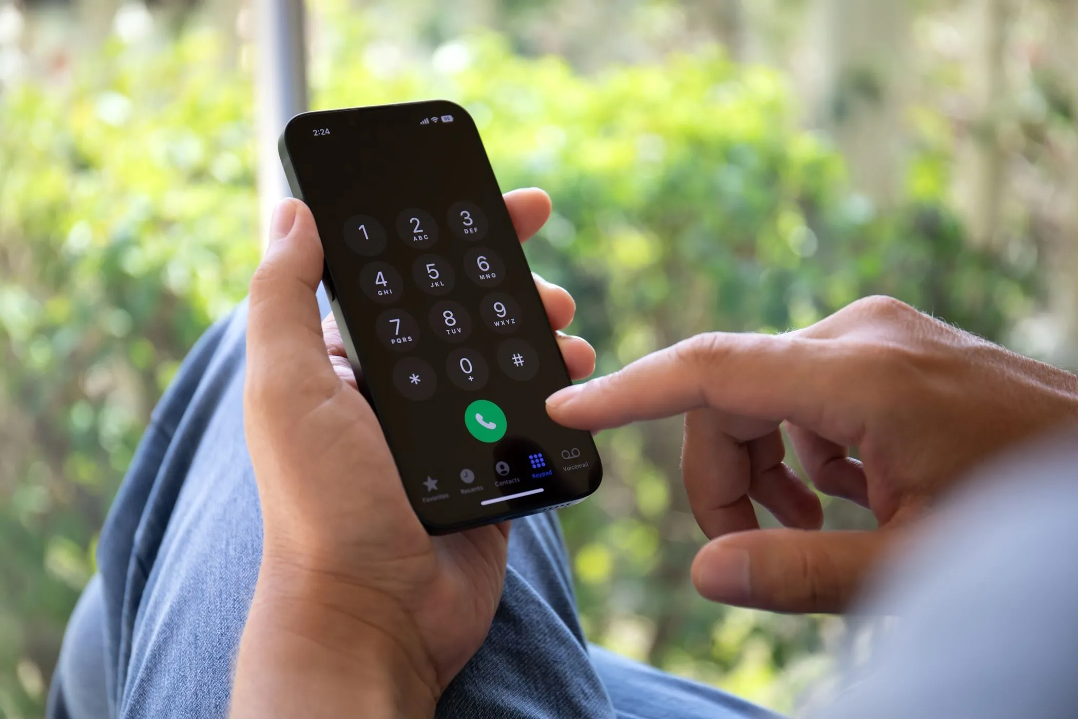 Người đàn ông nhập số điện thoại trên iPhone, thể hiện sự phụ thuộc của xác thực 2FA qua SMS vào thiết bị di động
