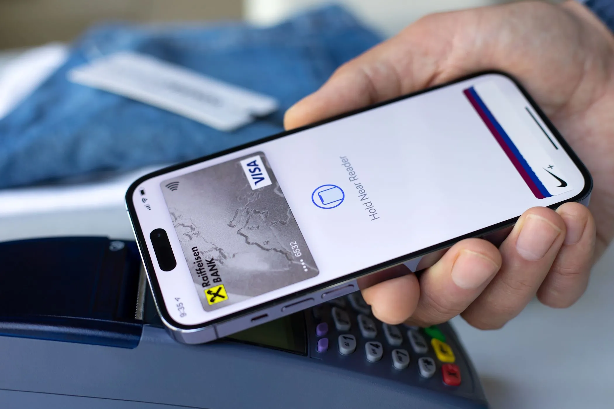 Người đàn ông thanh toán bằng Apple Pay trên iPhone tại cửa hàng, minh họa giao dịch bảo mật thông tin