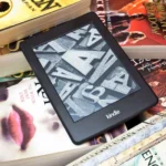 Người đọc Kindle trên chồng sách vật lý