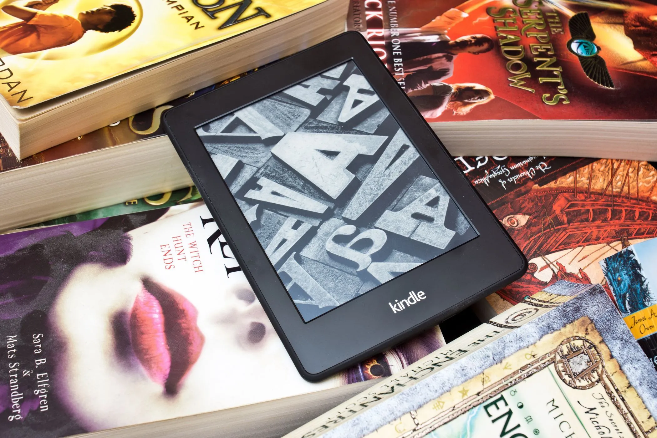 Người đọc Kindle trên chồng sách vật lý