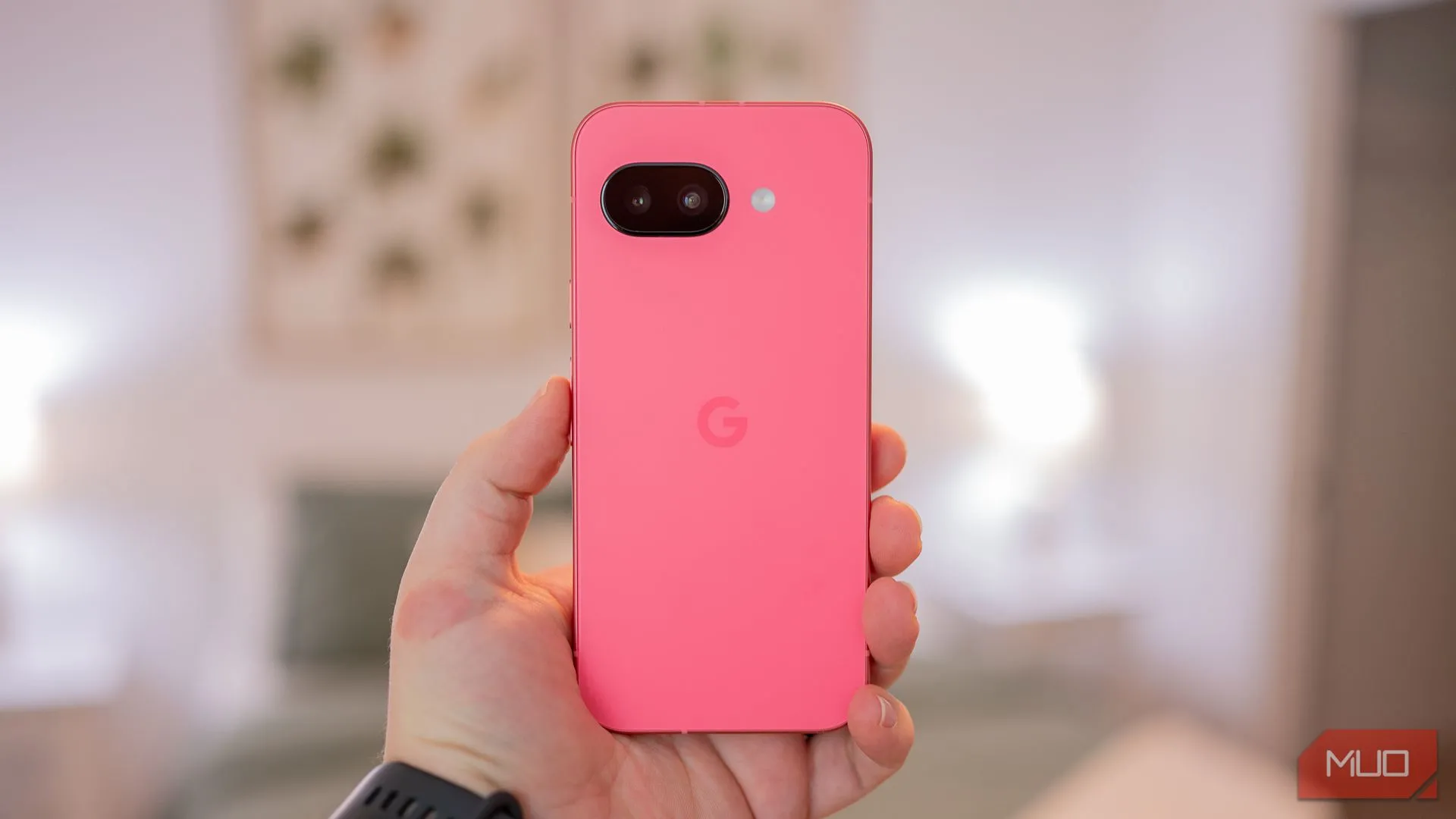Người dùng cầm điện thoại Google Pixel 9a, phô bày mặt lưng với thiết kế tối giản và màu sắc tinh tế