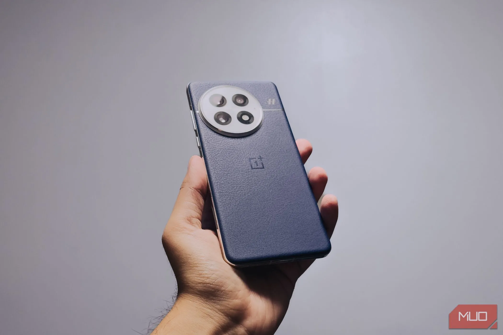 Người dùng cầm điện thoại OnePlus 13 màu Midnight Ocean, thể hiện công thái học và độ bám chắc chắn