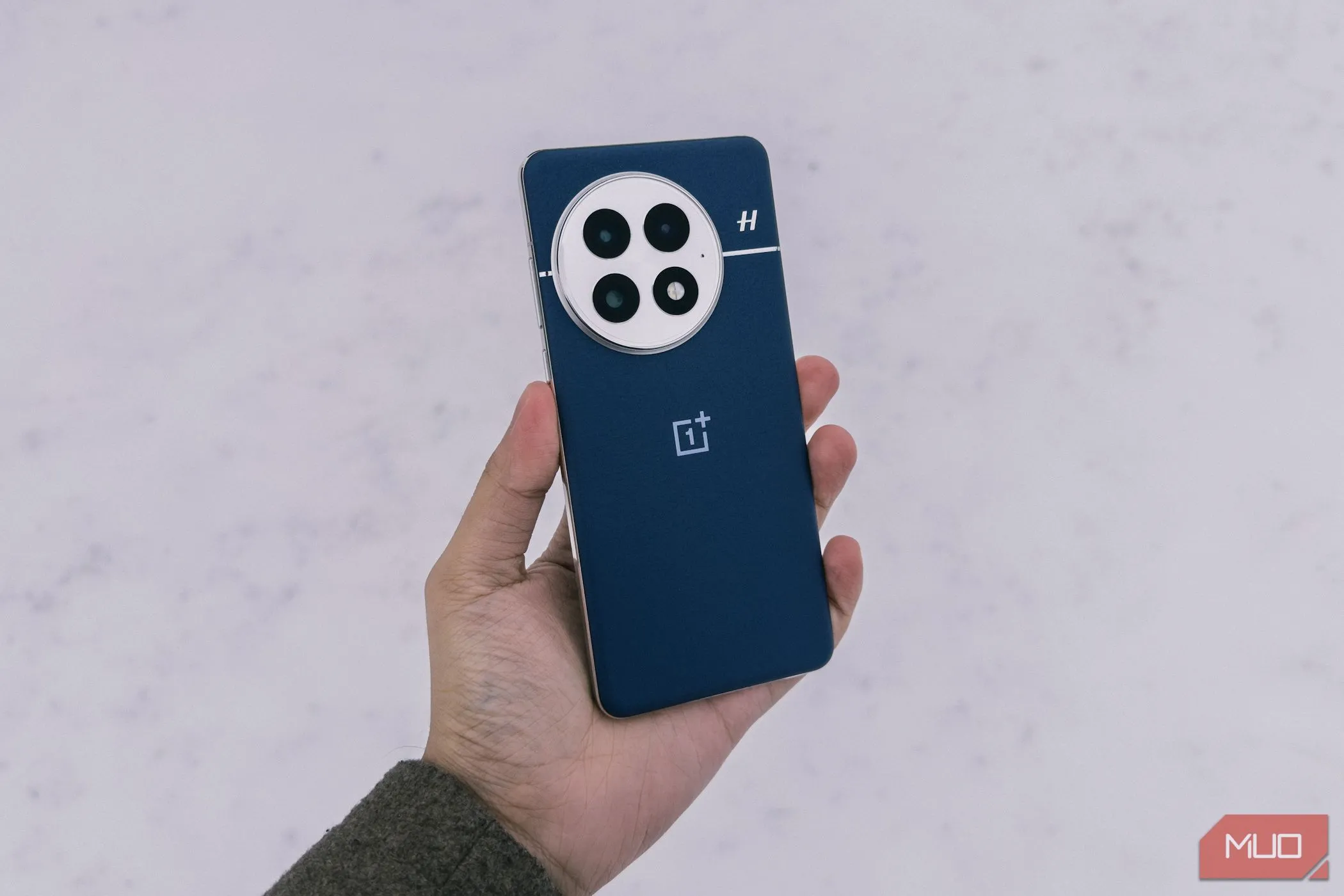 Người dùng cầm điện thoại OnePlus 13 trong môi trường tuyết phủ, minh họa độ bền và khả năng chống chịu
