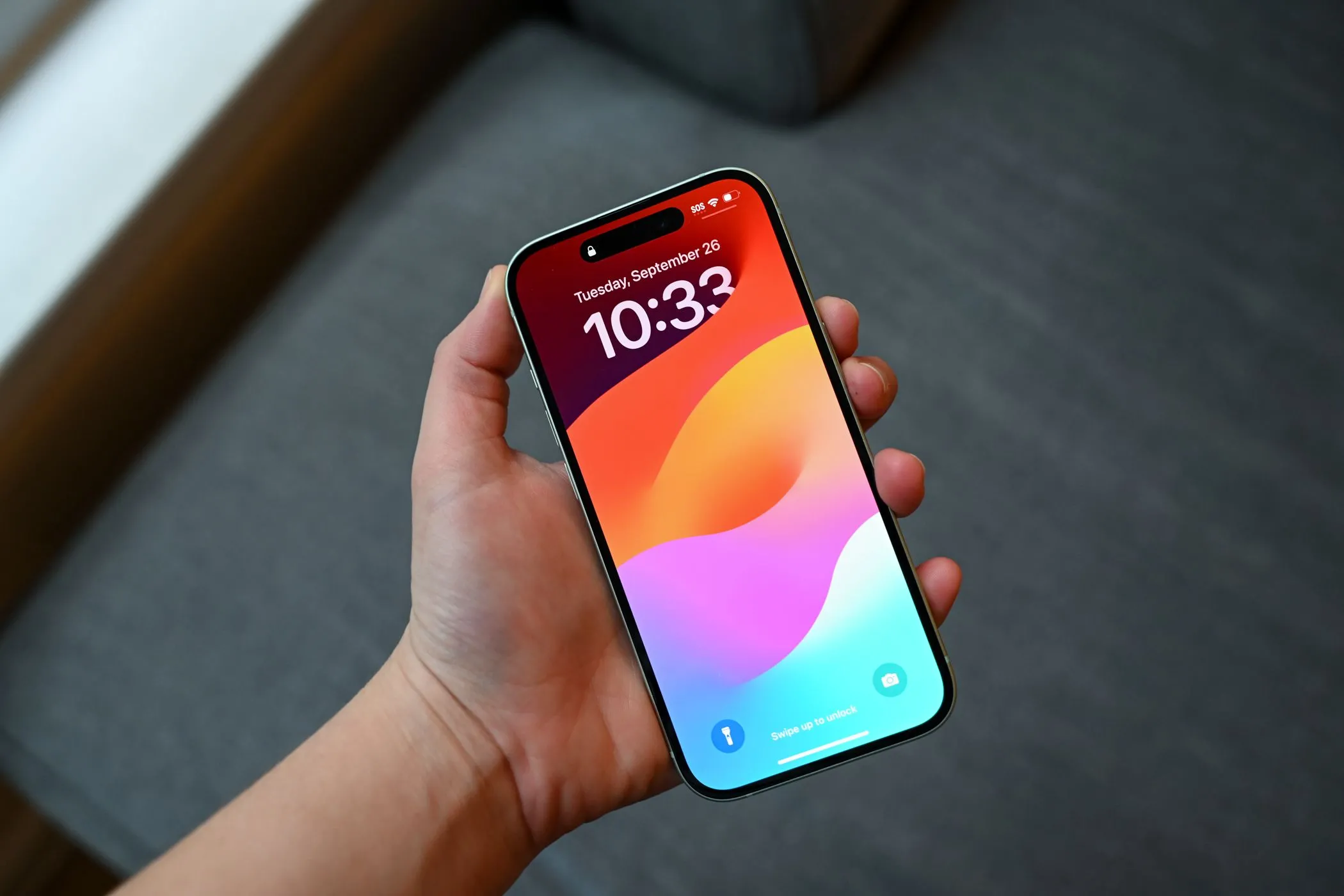 Người dùng cầm iPhone 15 ở màn hình khóa