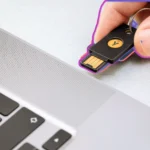 Người dùng cắm USB bảo mật YubiKey vào cổng laptop để khóa/mở khóa máy tính.