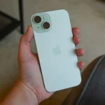 Người dùng đang cầm và trải nghiệm iPhone 15, thể hiện thiết kế sang trọng và màn hình Dynamic Island.