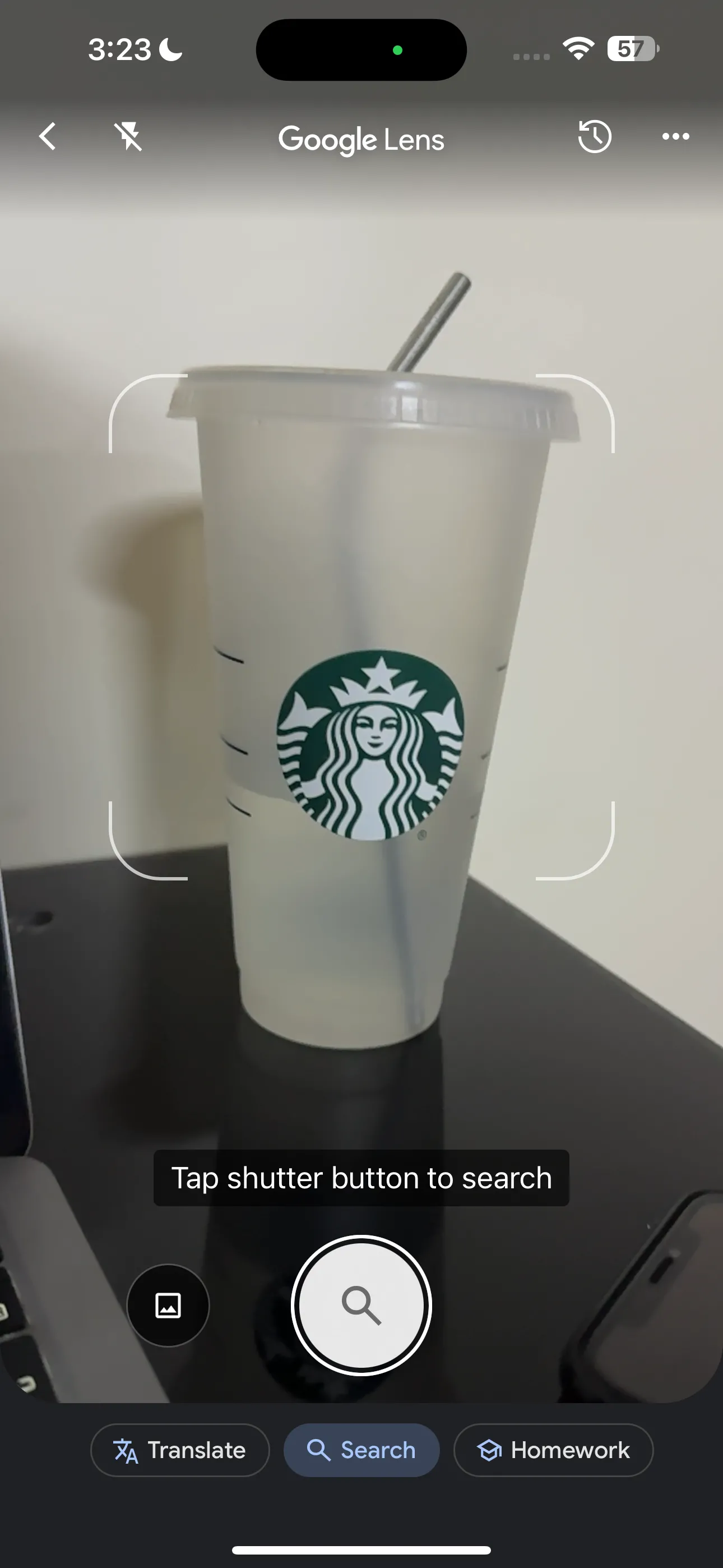 Người dùng đang hướng camera điện thoại sử dụng Google Lens vào ly Starbucks để tìm kiếm thông tin