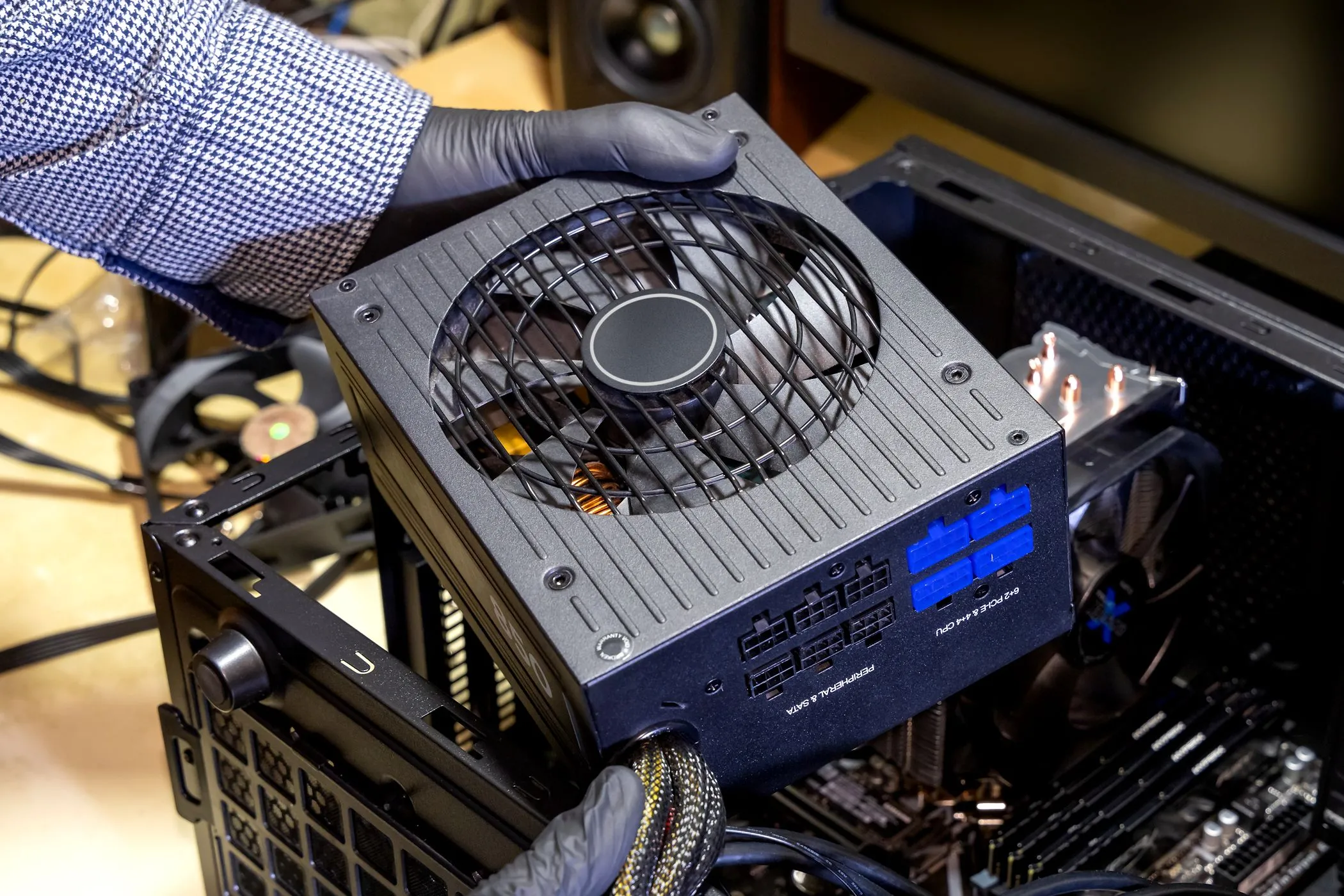 Người dùng đang lắp đặt bộ nguồn máy tính (PSU) vào vỏ case